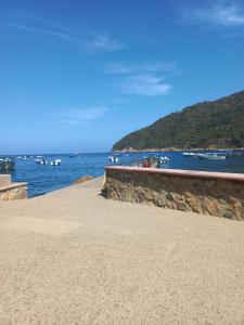 a beach with boats in a body of water at Casa El Limón in Yelapa +19 photos