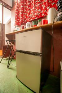 a small refrigerator in a kitchen with a counter at Hostal Nuevo Arenal downtown, private rooms with bathroom in Nuevo Arenal