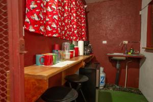 a kitchen with a counter with stools and a sink at Hostal Nuevo Arenal downtown, private rooms with bathroom in Nuevo Arenal