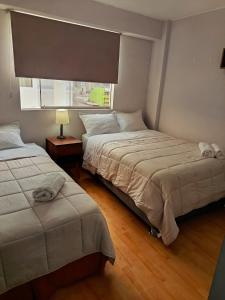 a bedroom with two beds and a window at Miraflores View in Lima
