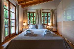 a bedroom with a large bed with two towels on it at Limonaia dei Dogi Entire 7BR Villa with Private Pool & Lake Garda View in Gargnano +60 photos