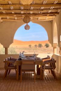 a dining room with a table and a view of the desert at Hotel Sunset Palace in Merzouga