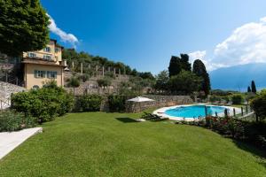 a garden with a swimming pool and a building at Limonaia dei Dogi Entire 7BR Villa with Private Pool & Lake Garda View in Gargnano