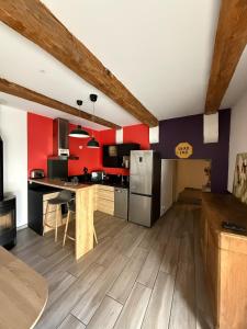 a kitchen with red and black walls and wooden floors at L'atelier in Capestang +21 photos