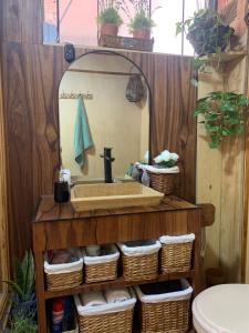 a bathroom with a sink and a mirror and baskets at Ma maison peruvienne- departamento muy cerca aéropuerto in Lima