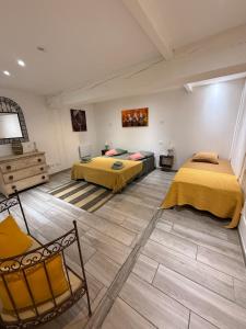 a room with two beds and a chair in it at L'atelier in Capestang