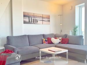 a living room with a blue couch and a table at Penthouse de Ool Blick auf das Wattenmeer in Neufeld +24 photos