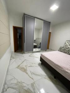 a bedroom with marble flooring and a bed and a mirror at Temporada Moto GP - 18km do autódromo de Goiania- acomoda 10 pessoas - Atlanta eventos in Goiânia +8 photos