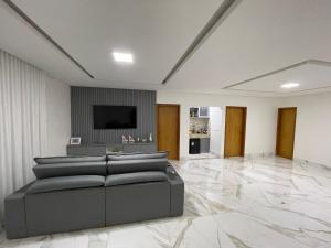 a living room with a couch and a tv on a wall at Temporada Moto GP - 18km do autódromo de Goiania- acomoda 10 pessoas - Atlanta eventos in Goiânia