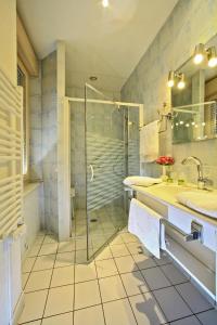 a bathroom with two sinks and a shower at Logis La Vieille Auberge, Art and Gallery in Souillac