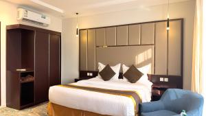 a bedroom with a large bed and a blue chair at فندق ذكرى in Taif