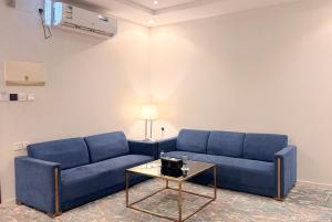 a living room with blue couches and a coffee table at فندق ذكرى in Taif +97 photos