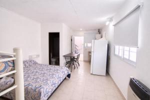 a bedroom with a bed and a table and a refrigerator at Gotas de Rocio N1 in San Antonio Oeste