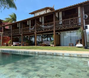 a house with a swimming pool in front of it at Gidu Ilhabela in Ilhabela
