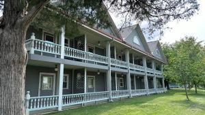 a large house with a porch and a tree at The Shelby Inn in Shelbyville