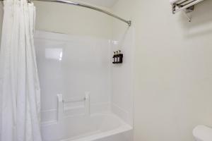 a white bathroom with a shower curtain and a tub at The Shelby Inn in Shelbyville +30 photos