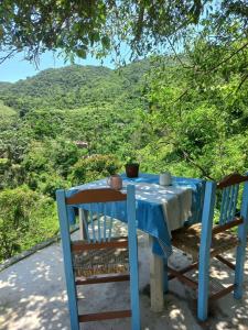 a blue table and chairs with a view of a mountain at Estudio La Higuera in Yelapa