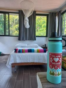 a bedroom with a bed in a room with windows at Estudio La Higuera in Yelapa +10 photos