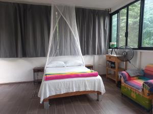 a bedroom with a bed with a mosquito net at Estudio La Higuera in Yelapa