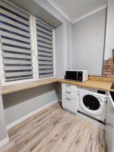 a laundry room with a washer and dryer on a counter at Apartament Centrum in Płock