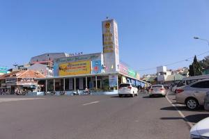 a busy street with cars parked in front of a building at Khu Hòa Bình in Da Lat