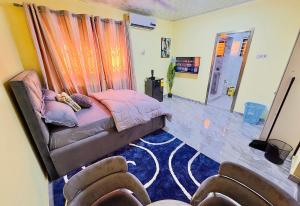 a bedroom with a bed and two chairs in it at Villa de chez nous in North Legon