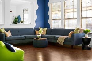a blue couch in a living room with a blue wall at Grand 6BR 3BA Pool Escape Round Rock in Round Rock