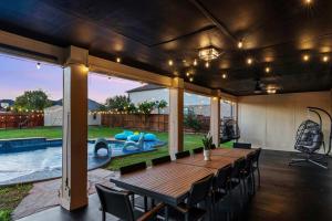 a patio with a table and chairs and a swimming pool at Grand 6BR 3BA Pool Escape Round Rock in Round Rock