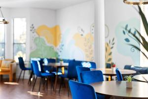 a restaurant with blue chairs and tables in a room at Grand 6BR 3BA Pool Escape Round Rock in Round Rock