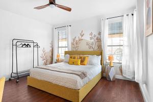 a bedroom with a bed with yellow pillows and a ceiling fan at Grand 6BR 3BA Pool Escape Round Rock in Round Rock +43 photos