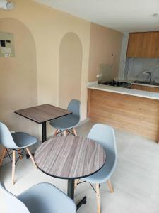 a room with two tables and chairs and a kitchen at Hostal Tayupanda in Quito