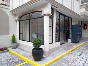 a building with a potted plant in front of it at Hostal Tayupanda in Quito