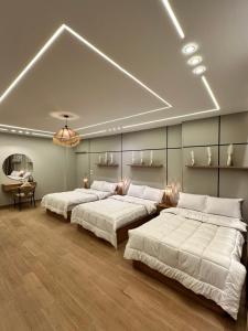 a bedroom with three beds and a chandelier at Calm Pyramids View Villa in Cairo