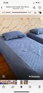 a picture of a bed with a blue comforter at MGerais Pousada in Visconde do Rio Branco