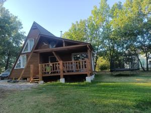 a home with a large porch and a deck at Mon petit chalet in Puycornet