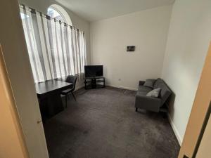 a living room with a table and a chair and a desk at Doncaster City Centre Immaculate 1 Bedroom flat in Doncaster