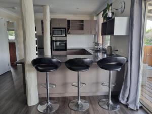 a kitchen with two black bar stools at a counter at Gympie Townhouse in Gympie