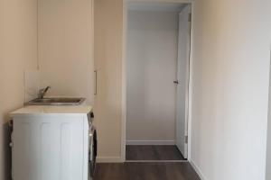 a small white kitchen with a sink and a door at Gympie Townhouse in Gympie