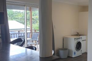 a kitchen with a washing machine and a balcony at Gympie Townhouse in Gympie