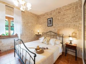 a bedroom with a bed and a brick wall at Charming Villa with Private Garden & BBQ in Barban