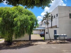 a tree in front of a building with a table at kitnet08 para 04 pessoas bem localizada garagem in Ourinhos