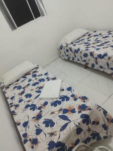 a room with a bed with a flowered bedspread at Torres Residence 2 in Recife