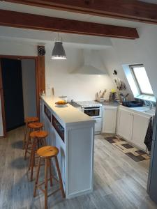 a kitchen with a counter and some stools in it at Mon petit chalet in Puycornet +18 photos
