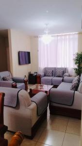 a living room with couches and a tv at Urbanization Maratea in Manta