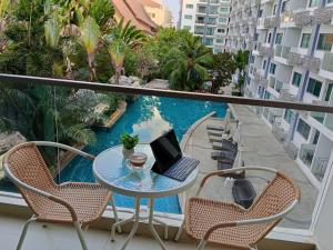 a balcony with a table with a laptop on it at คลับรอยัล2bed in North Pattaya