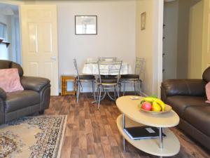 a living room with a couch and a table with a bowl of fruit at Ashley Cottage in Bowmore