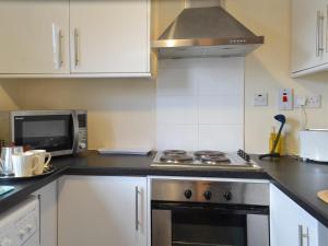 a kitchen with a stove and a microwave at Ashley Cottage in Bowmore