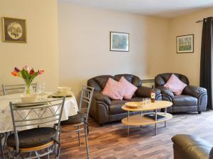 a living room with a couch and a table at Ashley Cottage in Bowmore