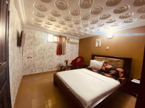 ein Schlafzimmer mit einem Bett und einer Decke, an der Teller hängen in der Unterkunft Bethany Hotel in Abidjan