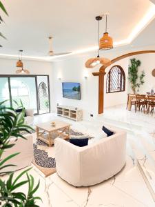 a living room with a white couch and a table at Uttoru Creek Villa-2 in Mombasa